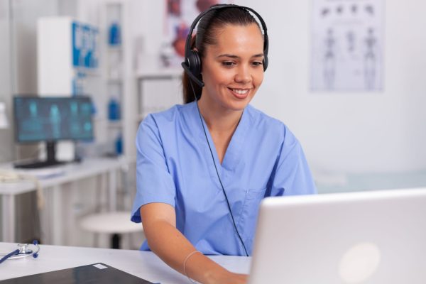 medical-staff-talking-with-patient-about-prescription-wearing-headset-with-microphone-hospital-office-virtual-assistant-for-medical-practice-sitting-desk-using-computer-modern-clinic-looking