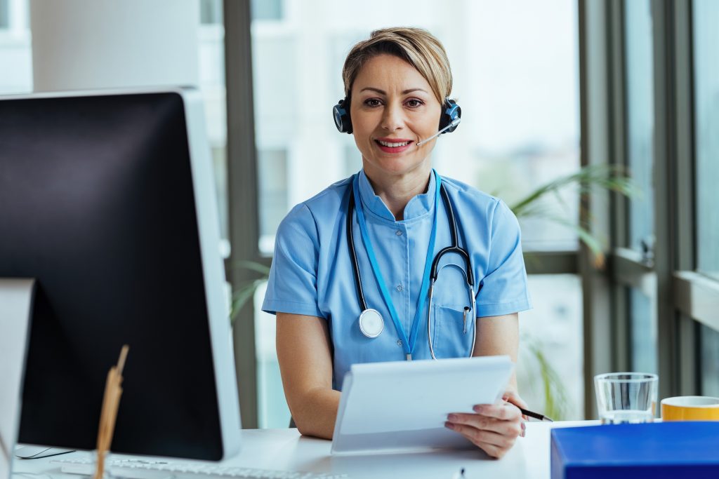 smiling-female-doctor-wearing-headset-while-working-as-virtual-assistant-for-medical-practice