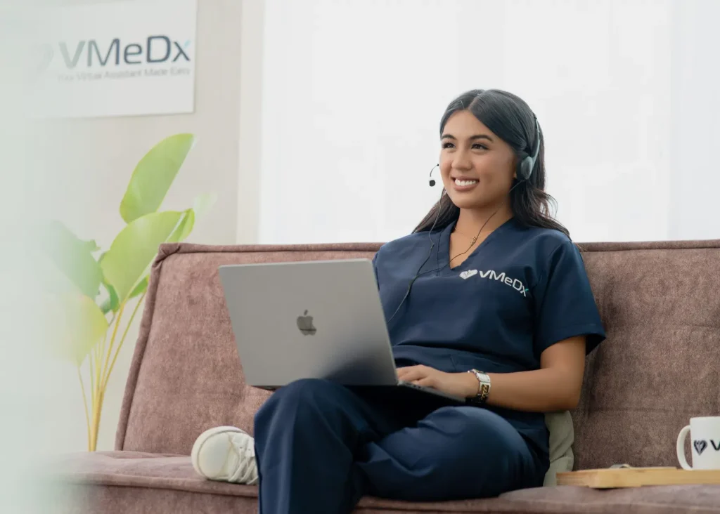 Female VMeDx remote medical scribe specilaist sitting at the couch, while working on her laptop