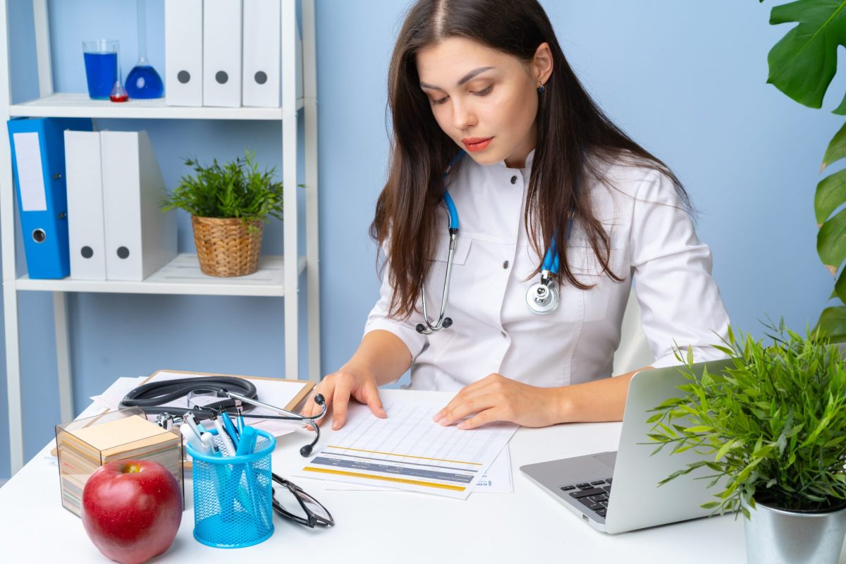 Female worker handling remote health data organization and updating medical records in office.